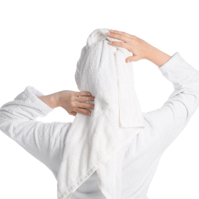 Woman drying her hair with a white towel, seen from behind
