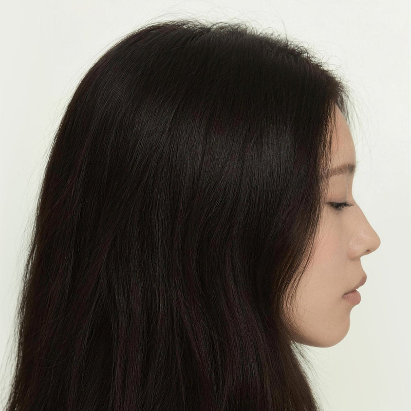 Side profile of a woman with long, straight dark hair